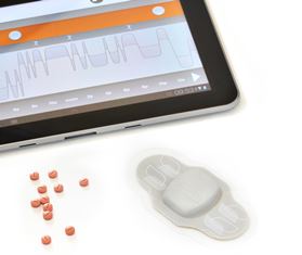 An electronic patch with pills and data collected shown on a tablet PC