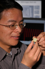 Huikai Xie, a University of Florida assistant professor of electrical and computer engineering, examines a tiny motion sensor