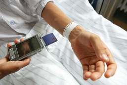 RFID chip in patient's wristband being read by a PDA